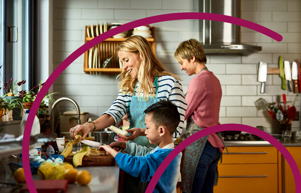 two adults in the kitchen with a child